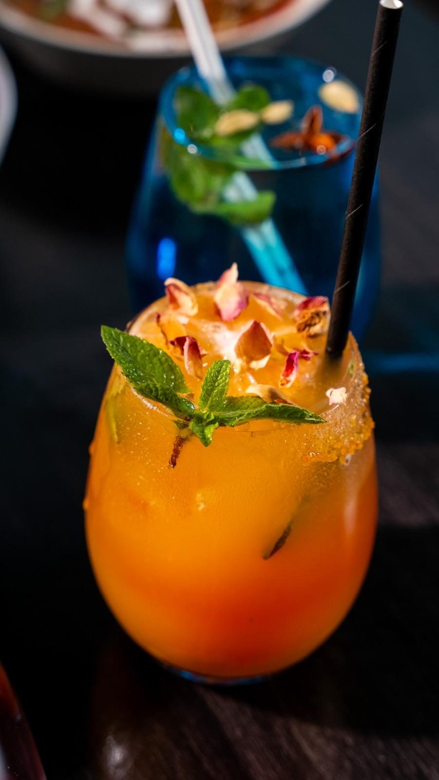 Mango cocktail with mint and an edible flower
